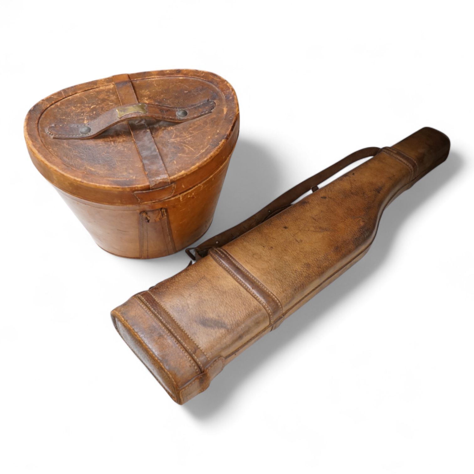 A 'Leg of Mutton' leather gun case and a top hat in leather case, gun case 75cm long.